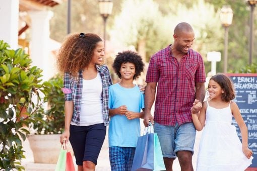 A happy family walks down a sidewalk together