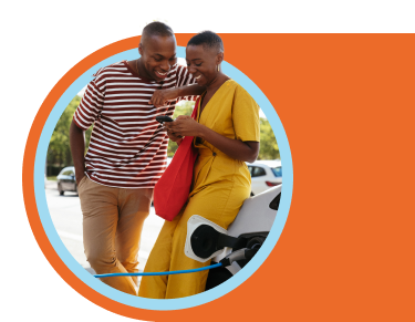 Young couple leans against car while it charges at an EV station