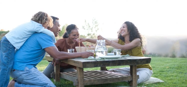 Grandparents share a meal with their daughter and grandchild.