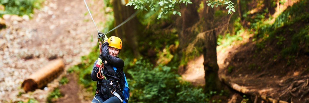 A woman rides a zip line.