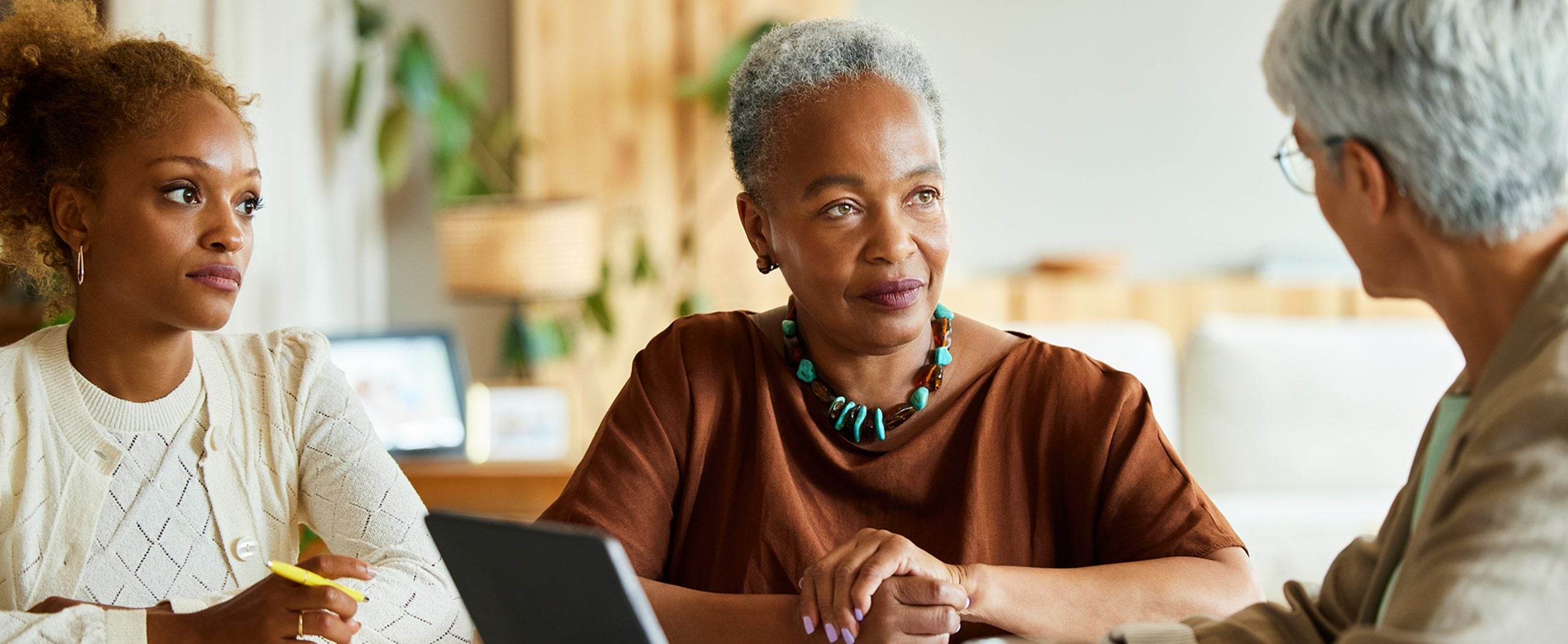 A retiree consults a financial planner with her daughter.